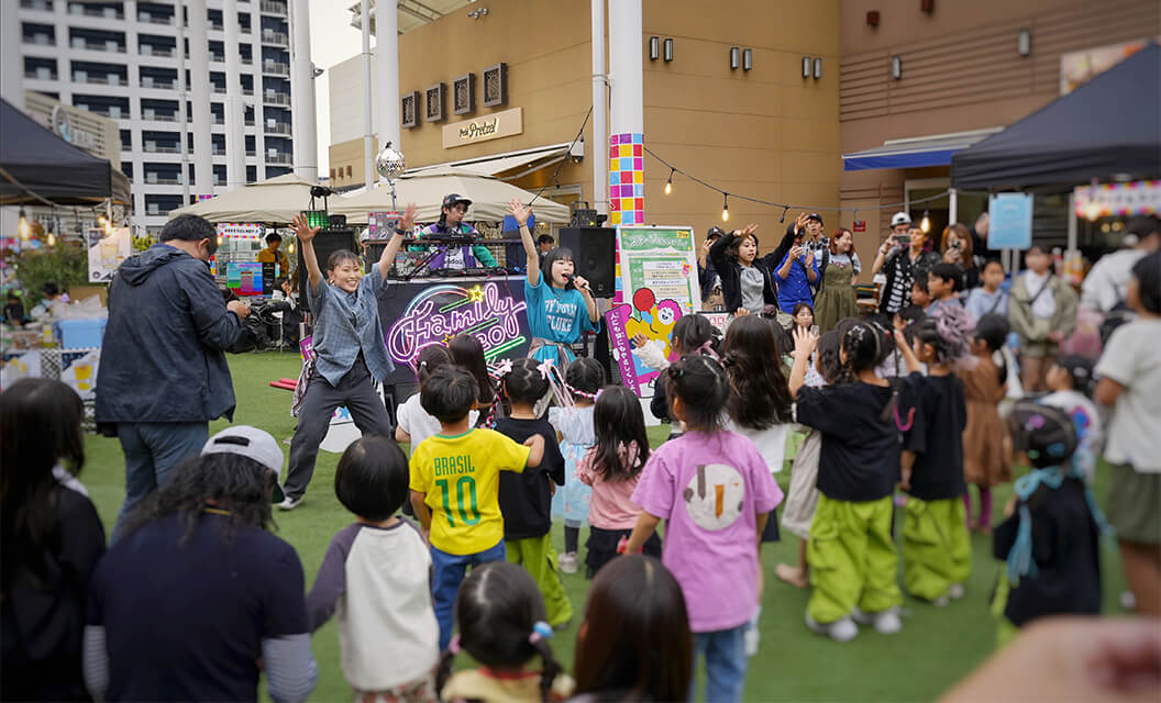 商業施設の屋外広場で行った親子ディスコ。講師のリードで子どもたちが一緒に踊っている様子